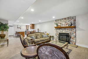 Living area with light colored carpet, recessed lighting, a fireplace, and a textured ceiling