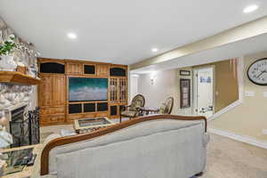 Living room featuring light carpet, recessed lighting, and a fireplace