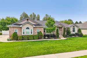 Single story home with brick siding, stucco siding, and roof with shingles