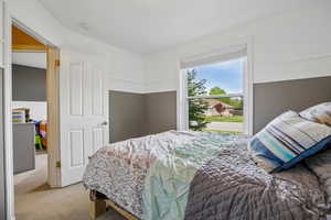 Bedroom featuring carpet floors and wainscoting