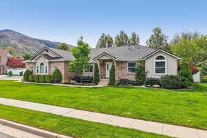 Ranch-style house featuring brick siding, a mountain view, and roof with shingles