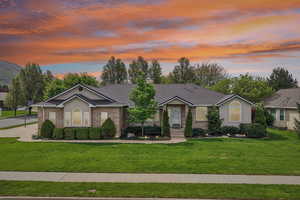 Ranch-style house with a lawn, brick siding, and a shingled roof