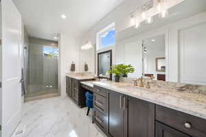 Bathroom with two vanities, a shower stall, recessed lighting, and light marble finish floors