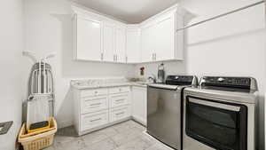 Laundry room featuring washer and dryer and cabinet space