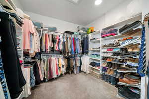 Walk in closet featuring light colored carpet