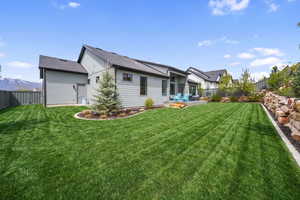 Back of property with a fenced backyard, board and batten siding, roof with shingles, and a mountain view