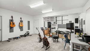 Exercise area featuring light colored carpet and baseboards