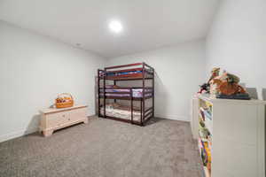 Bedroom with light colored carpet and baseboards