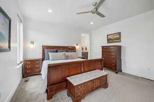 Bedroom with ensuite bathroom, light carpet, a ceiling fan, and recessed lighting
