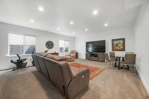 Living area with light colored carpet and recessed lighting