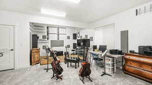 Office area featuring light carpet and baseboards