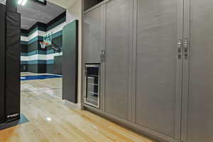 Interior space with light wood-style floors and wine cooler