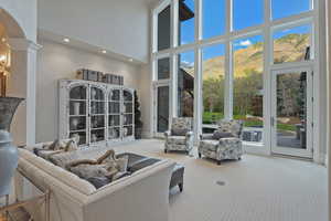 Living room with a mountain view, a high ceiling, carpet, arched walkways, and recessed lighting