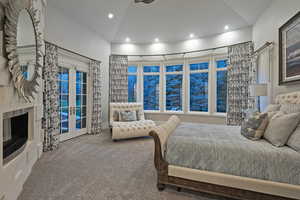 Carpeted bedroom with access to exterior, a tiled fireplace, recessed lighting, lofted ceiling, and french doors