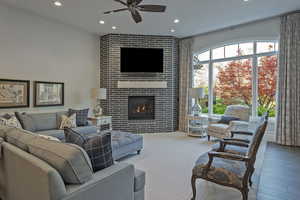 Living room with a ceiling fan, a tile fireplace, recessed lighting, and hardwood / wood-style floors
