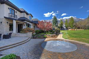 Patio / terrace featuring a lawn, a patio, and a mountain view