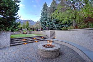 View of patio / terrace featuring an outdoor fire pit, a mountain view, and a putting area