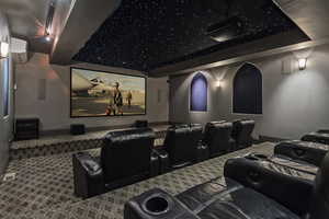Carpeted home theater room with a mini split for heating / cooling and baseboards
