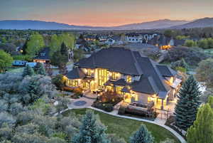 Rear view of property with a fire pit, a patio, a mountain view, and a yard