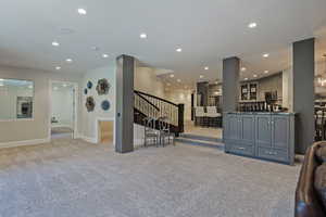 Living area with recessed lighting and light colored carpet