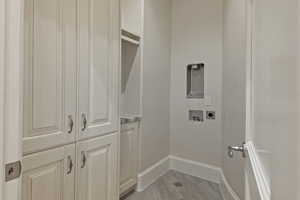 Laundry room featuring cabinet space, light wood-style flooring, and washer hookup