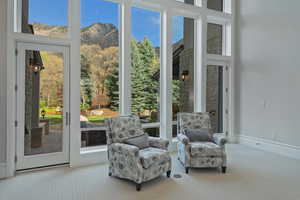 Doorway with carpet floors, a mountain view, and a high ceiling