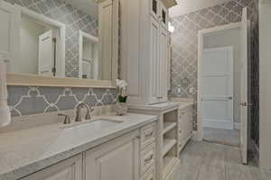 Bathroom featuring vanity and wallpapered walls