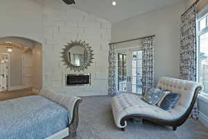 Bedroom with arched walkways, lofted ceiling, carpet, french doors, and recessed lighting