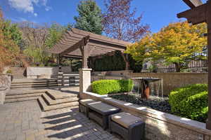 View of patio with an outdoor kitchen and a pergola