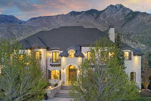 French provincial home with a chimney, a mountain view, and brick siding