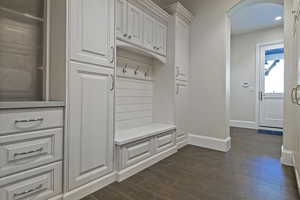 Mudroom featuring arched walkways, dark wood-style flooring, and recessed lighting
