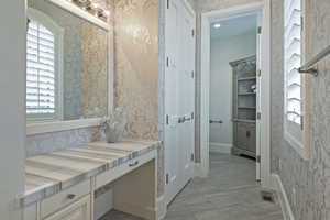 Bathroom with wallpapered walls and vanity