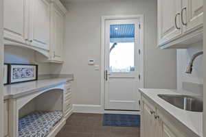 Laundry room featuring a sink and baseboards