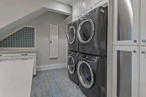Laundry room with cabinet space, light wood-type flooring, and vaulted ceiling