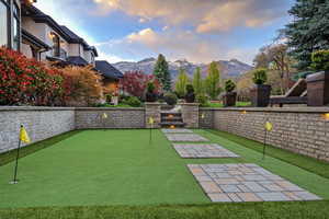 View of yard featuring a patio, an area to practice putting, and a mountain view