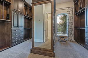 Walk in closet featuring dark colored carpet