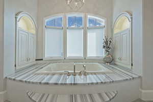 Full bathroom featuring a bath and suspended lighting