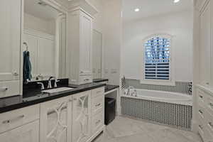 Full bath featuring vanity, a garden tub, and recessed lighting