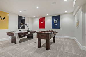 Recreation room with light carpet and recessed lighting