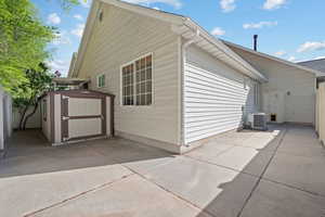 View of property exterior with a shed and a patio
