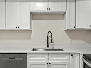 Kitchen featuring white cabinets, stainless steel dishwasher, and electric range