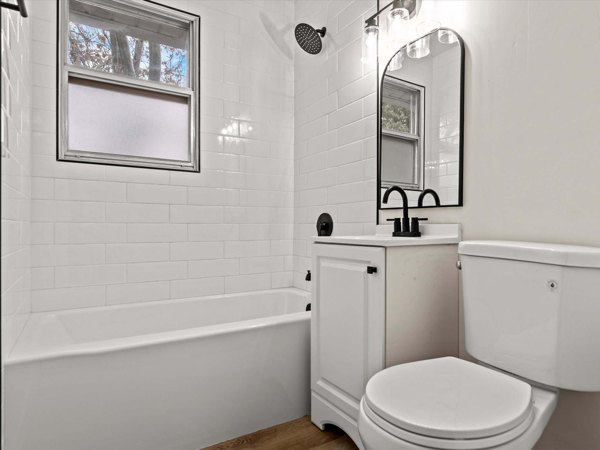 Bathroom with vanity, shower / washtub combination, and wood finished floors
