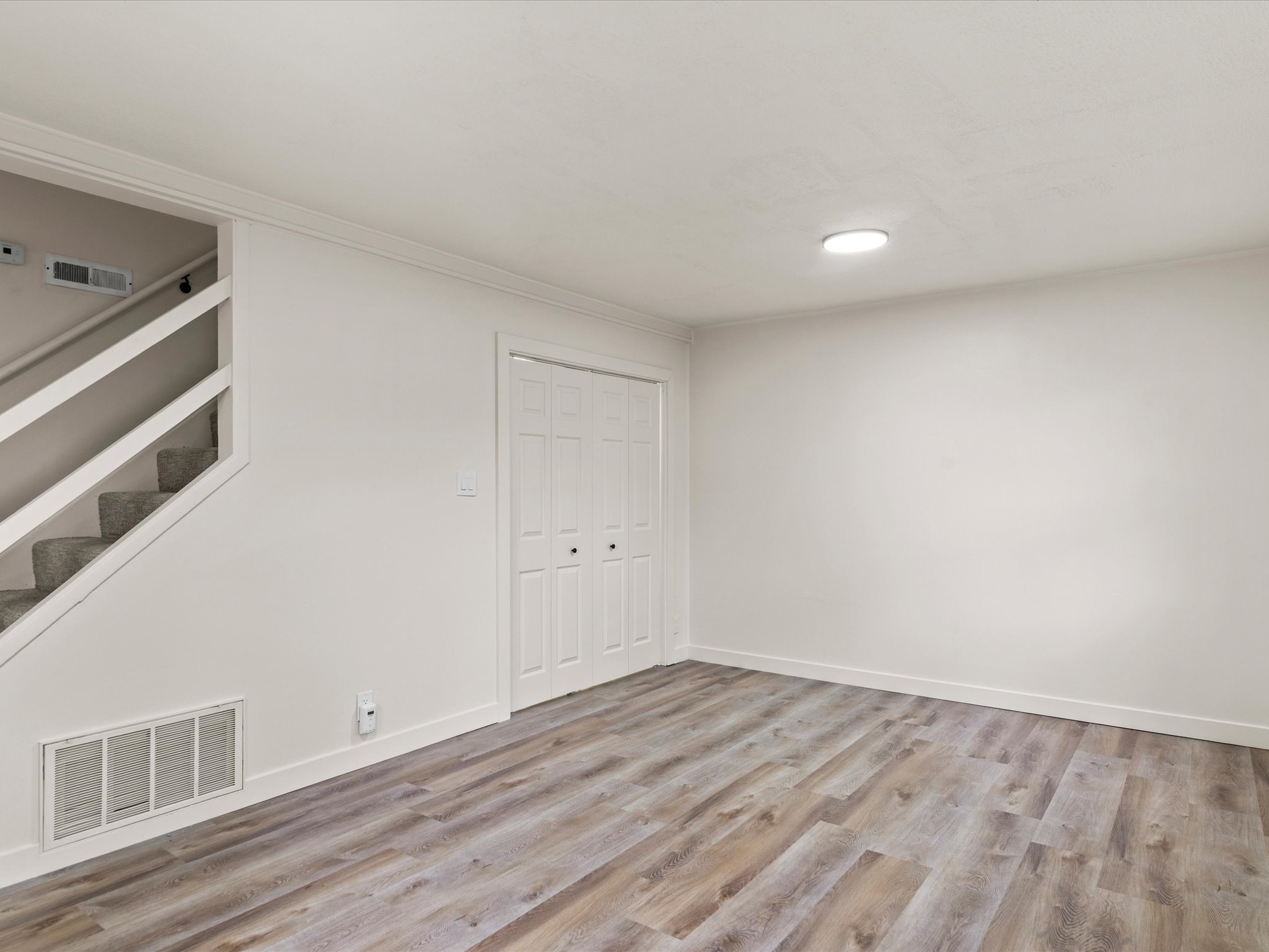 Basement featuring light wood-style floors and built in shelves