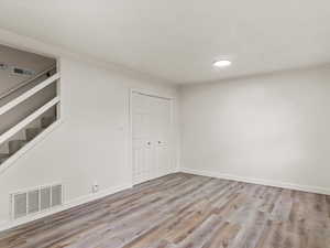 Basement featuring light wood-style floors and built in shelves