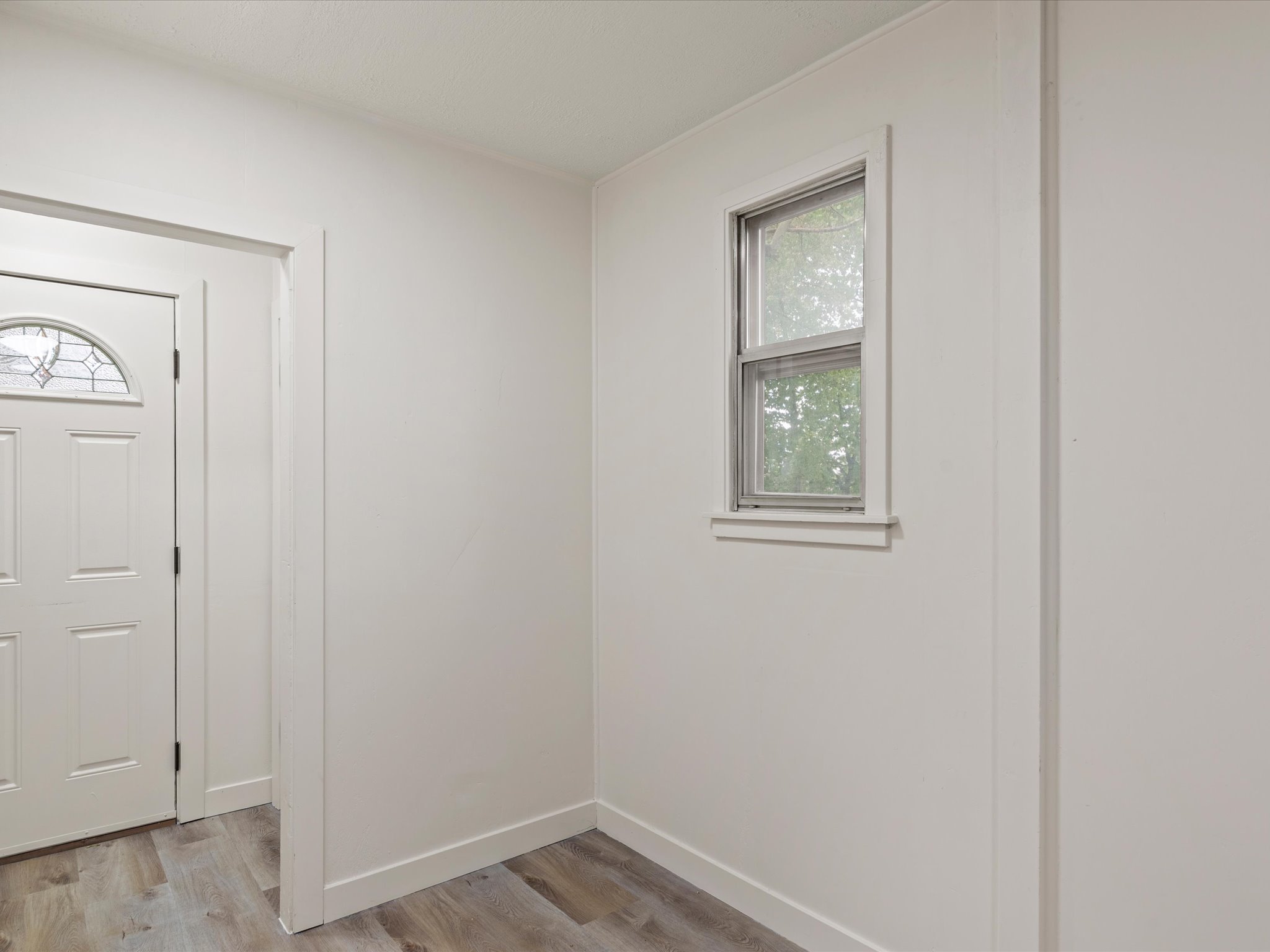 Foyer featuring light wood finished floors and baseboards