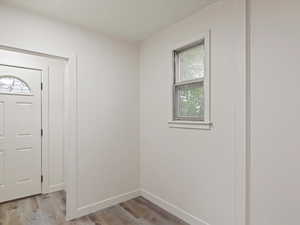 Foyer featuring light wood finished floors and baseboards