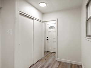 Foyer entrance with light wood-style floors and a textured ceiling