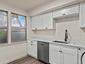 Kitchen featuring white cabinets, dishwasher, and dark wood-style floors