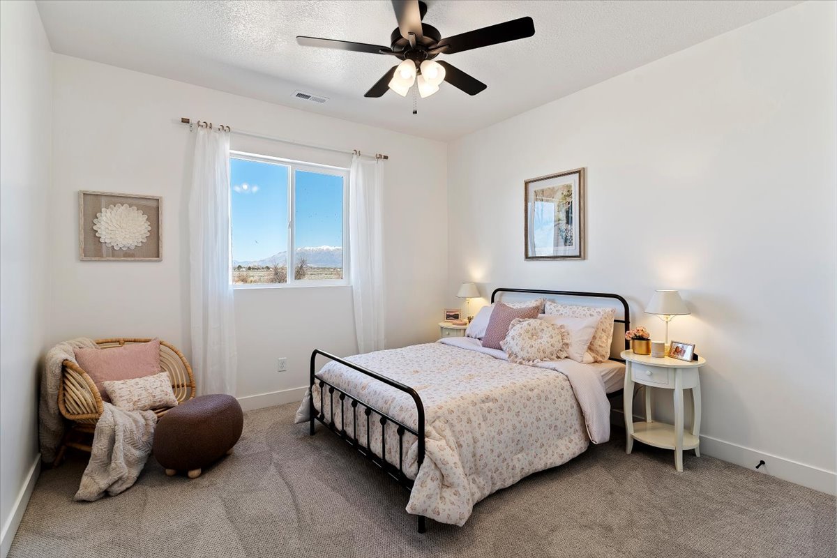 Carpeted bedroom featuring baseboards and ceiling fan