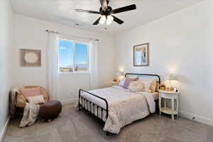 Carpeted bedroom featuring baseboards and ceiling fan